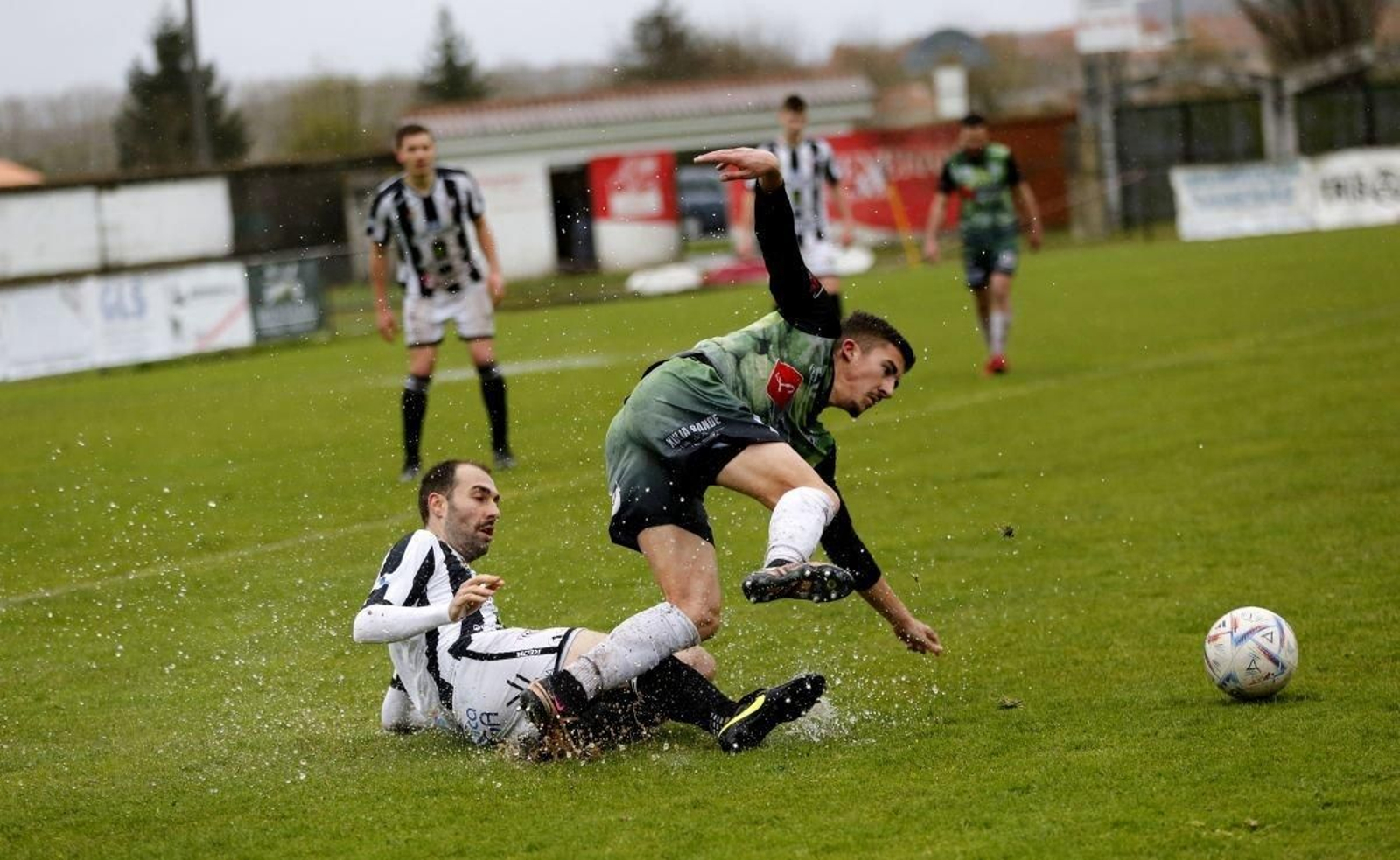 El defensa antelano Breixo se arroja al suelo para frenar el avance del extremo Charly, del Atlético Arnoia.