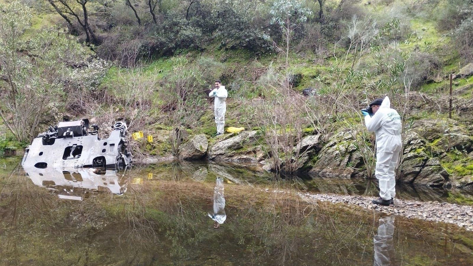 Agentes de la Guardia Civil fotografían y toman evidencias de una pieza hallada en una arroyo en la zona del accidente ferroviario en Adamuz