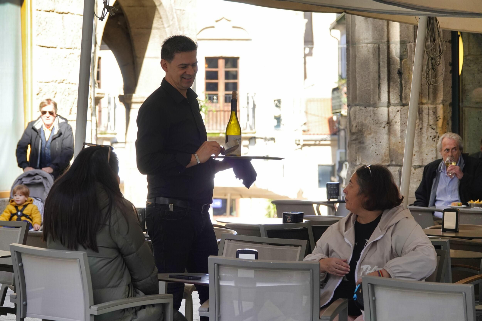Un camarero sirviendo a clientes en una terraza de Vigo.