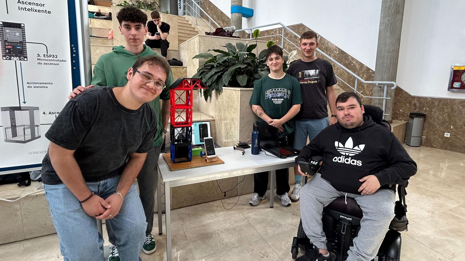 Pablo, Juan, Samuel, Diego y Raúl enseñan con una maqueta a pequeña escala cómo funciona su software.