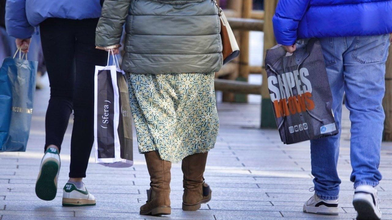 Personas con bolsas de tiendas de ropa, en Vigo. // Vicente Alonso