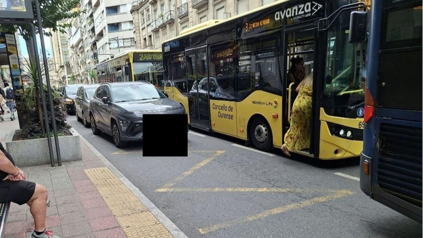 Coches aparcados en la parada de Curros Enríquez en hora punta.
