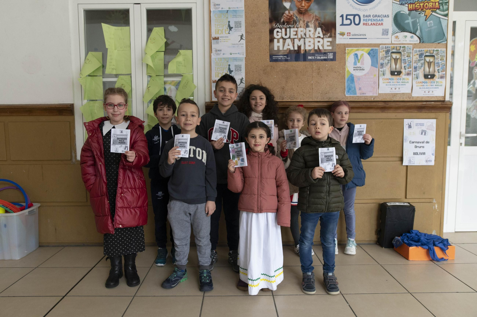 Los niños sostienen los pasaportes simbólicos con que viajaron por el mundo.