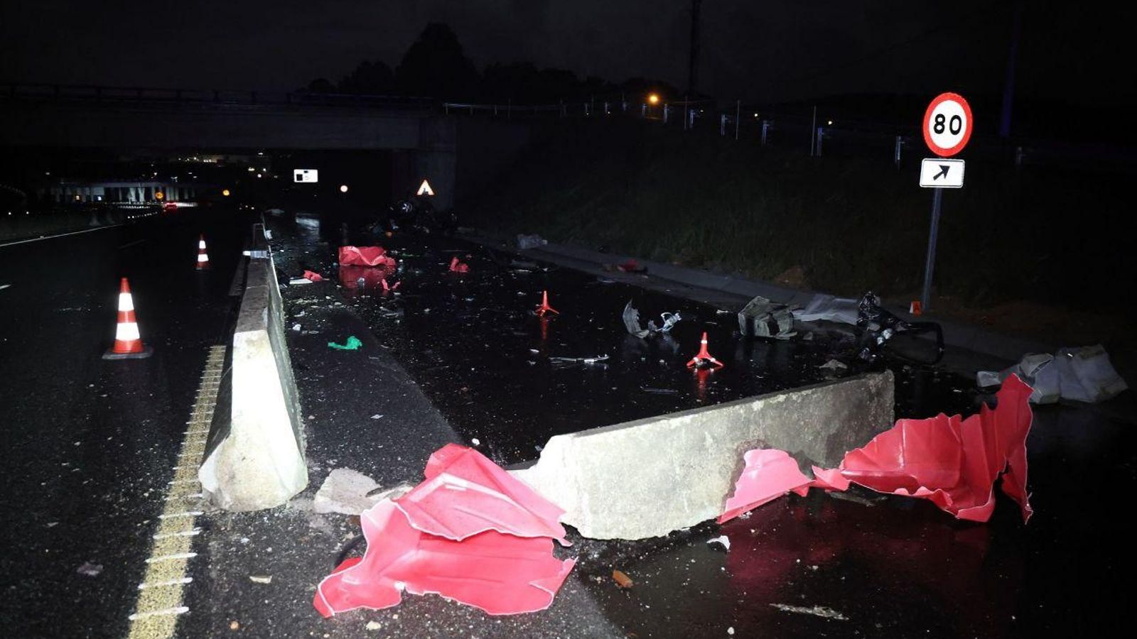 Los restos del coche siniestrado por la carretera y el destrozo causado a las vallas. // Alberte