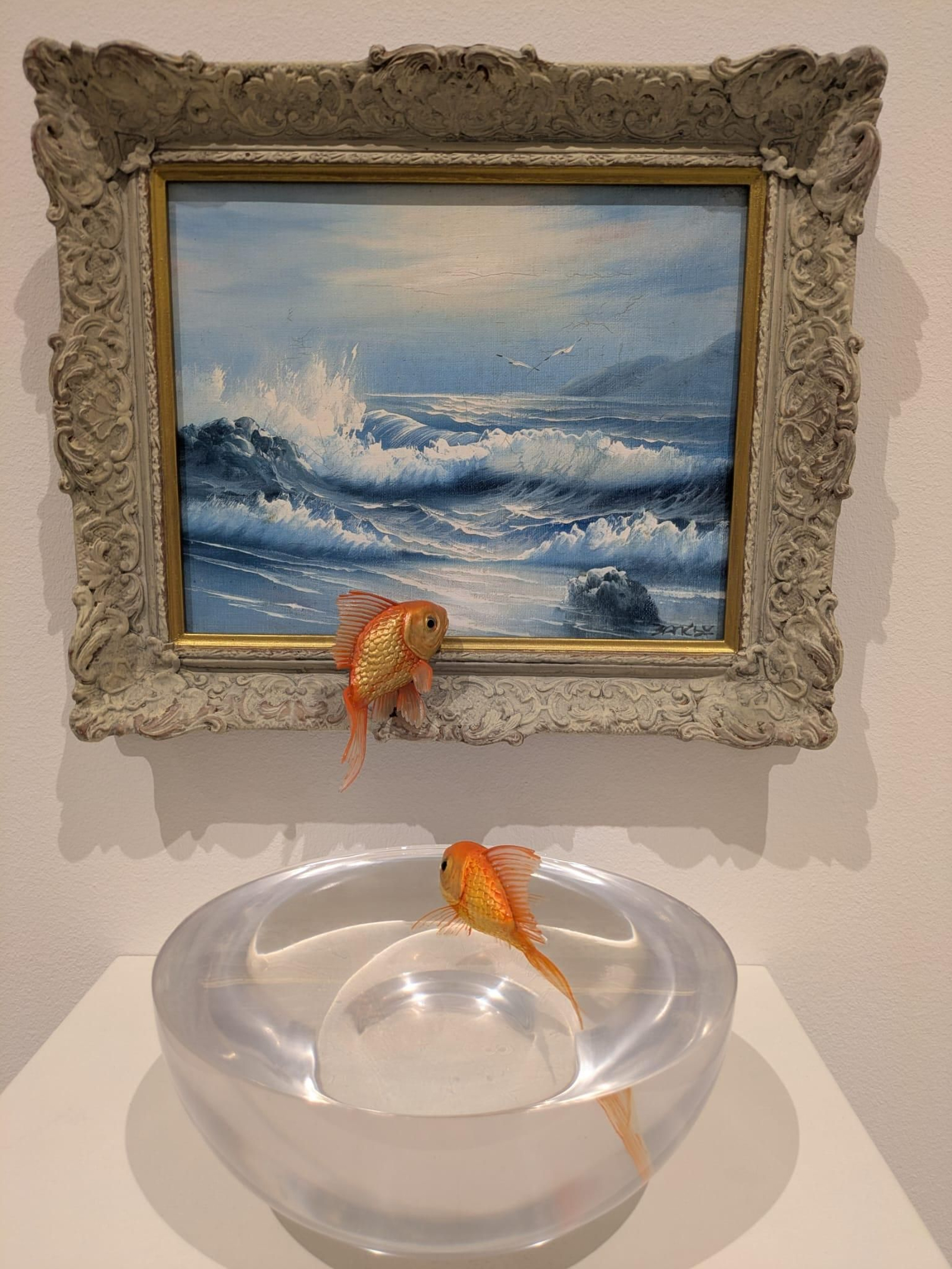 Esta obra es una pieza escultórica titulada Goldfish Bowl, creada por el artista británico Banksy.