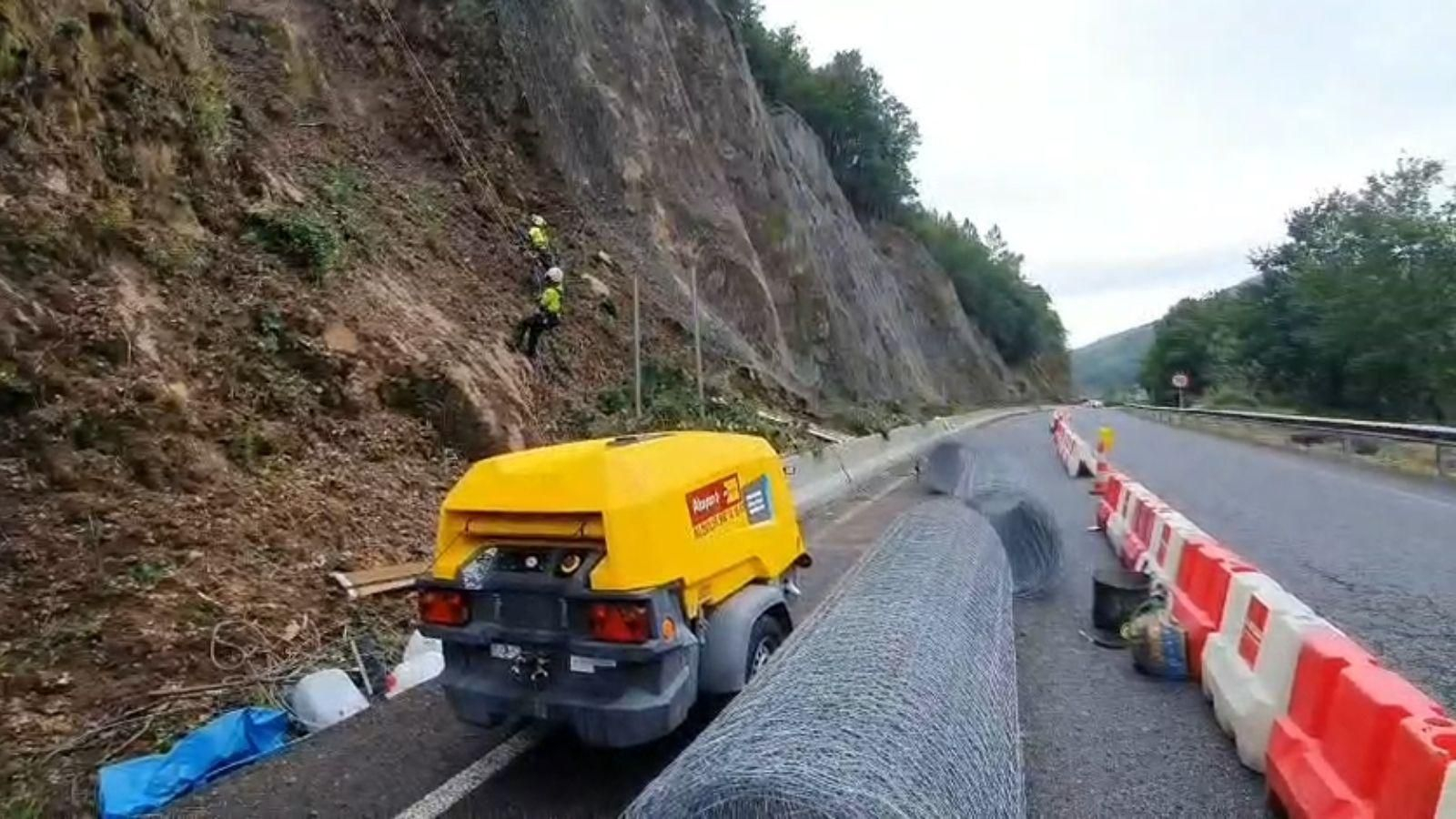 Los trabajadores actúan este viernes en el terraplén de la N-120 para cambiar la red y evitar nuevos desbordamientos en la carretera.