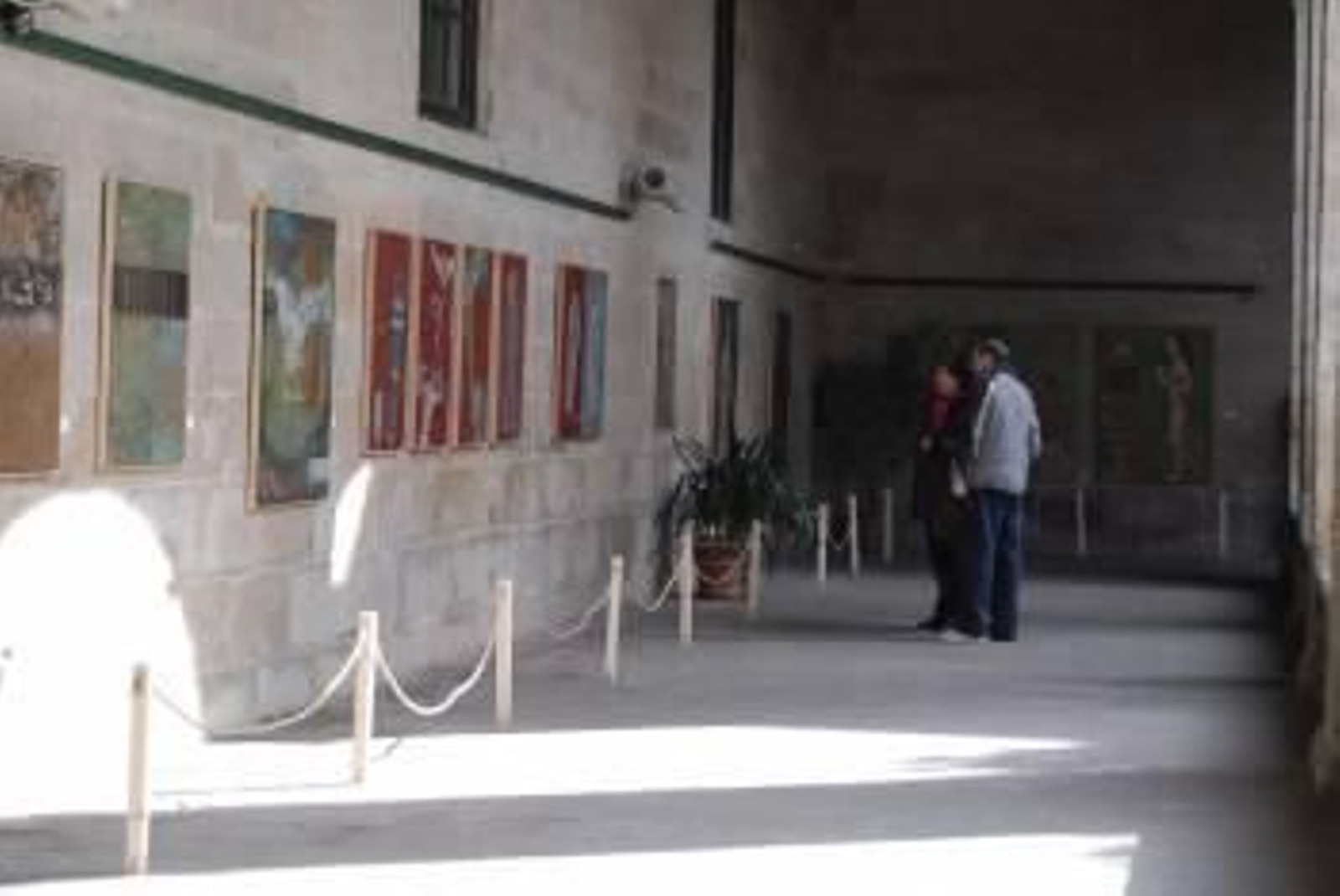 Varias personas  observan las obras expuestas.