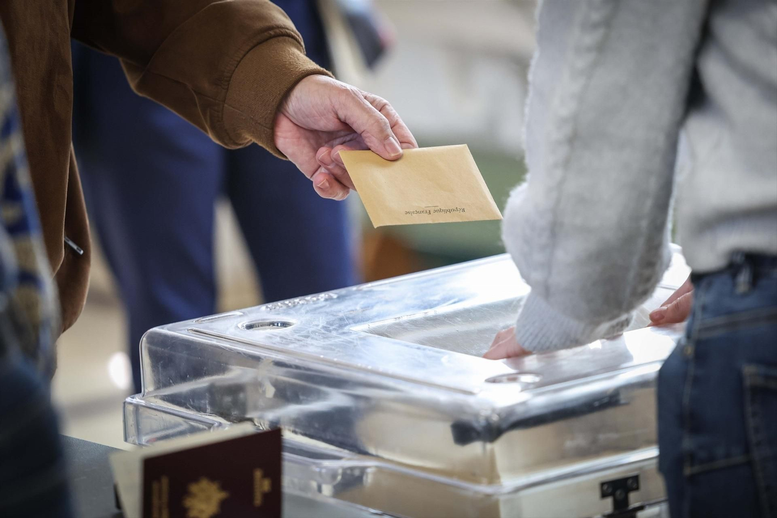 Una persona vota en urna en París