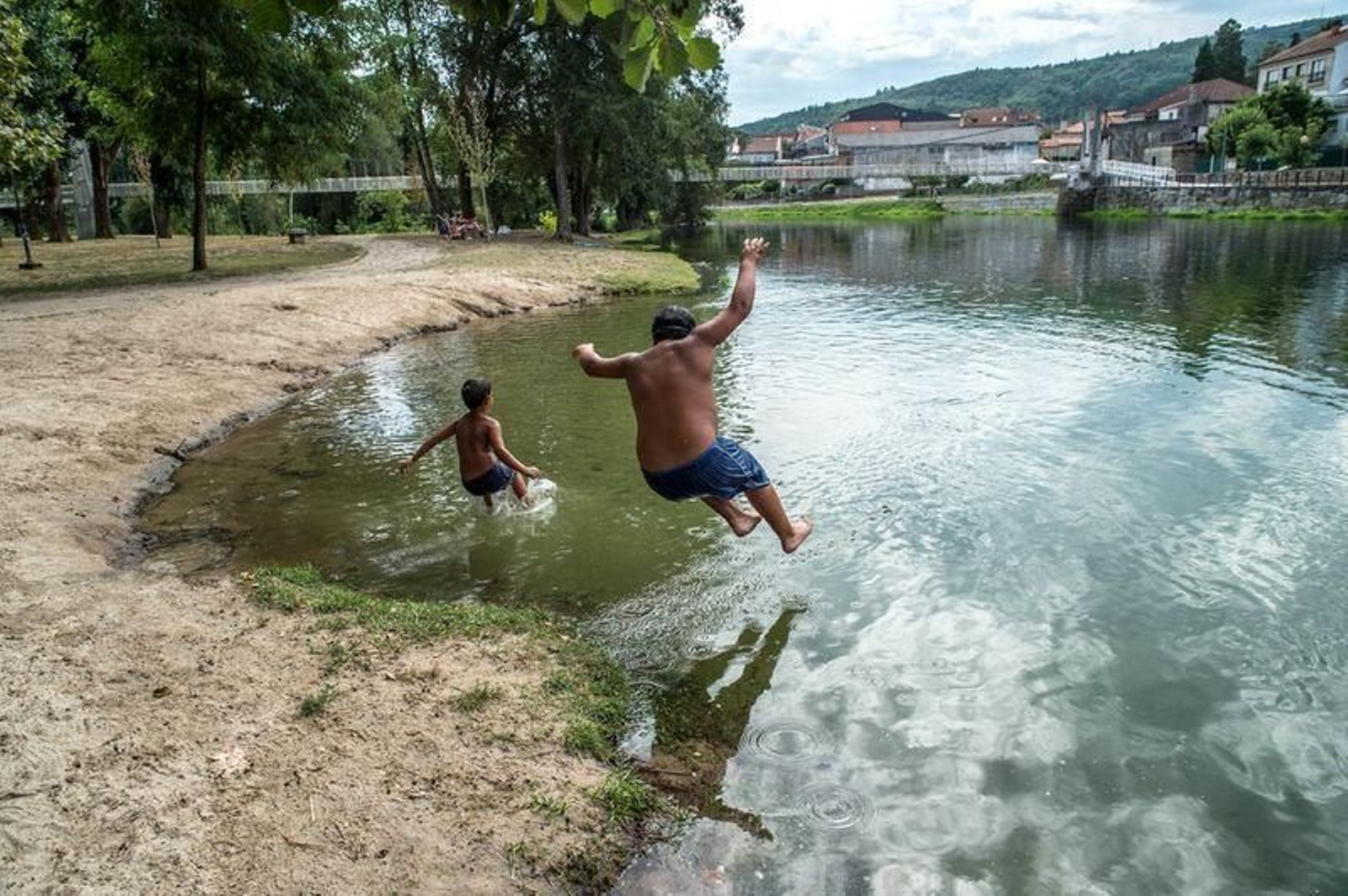 Dos personas se "tiran" al agua en la playa fluvial de Leiro (ÓSCAR PINAL).