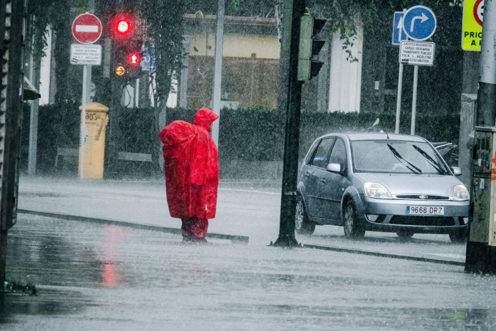 Un transeúnte en Vigo aguanta el chaparrón con un gran chubasquero muy peculiar