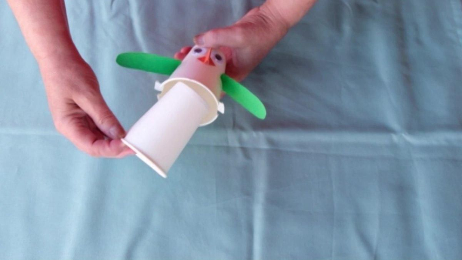 Para continuar e cando teñas o boneco totalmente decorado nun dos vasos de papel, o que terás que facer é cortar dúas pestaniñas na parte inferior, o lado polo que se bebe. Unha vez que estean dobradiñas, introduce o vaso ó que non lle fixemos nada dentro do que está decorado.