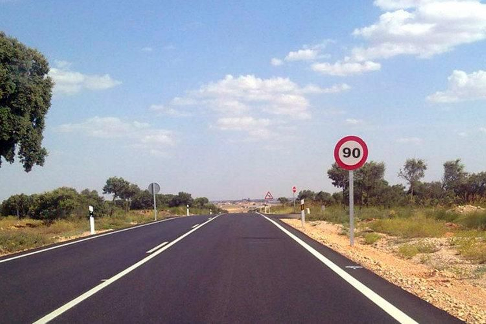 Imagen de una señal que limita a 90 km la velocidad en una carretera convencional.