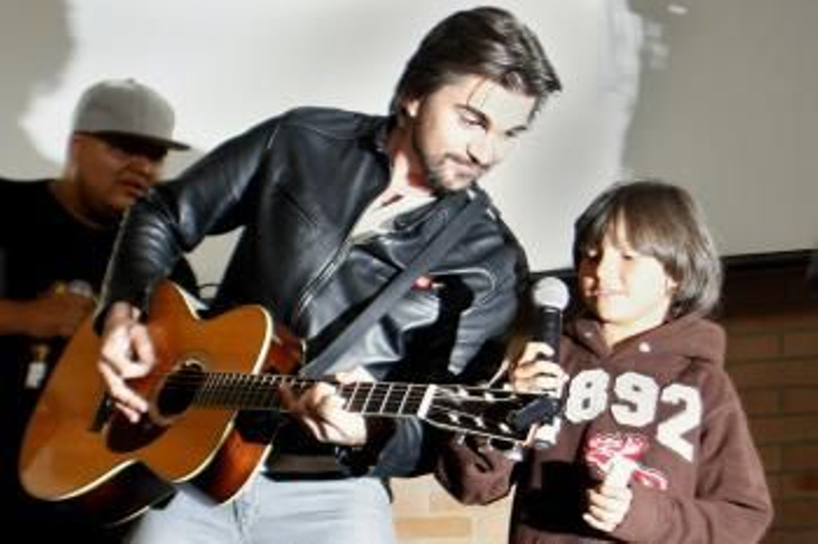Juanes canta con un niño durante el lanzamiento de la campaña 'Soñar es un Derecho', en Colombia.