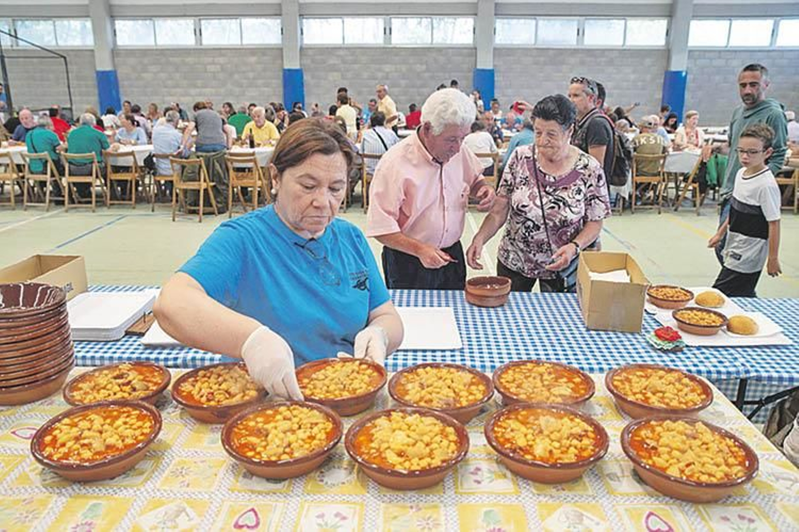 Una persona reparte raciones de callos limiaos durante una pasada edición de la fiesta.