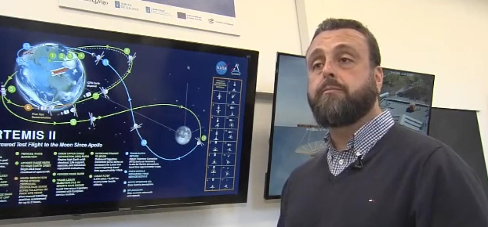Carlos Ulloa junto a una pantalla informativa de la trayectoria de la misión Artemis II