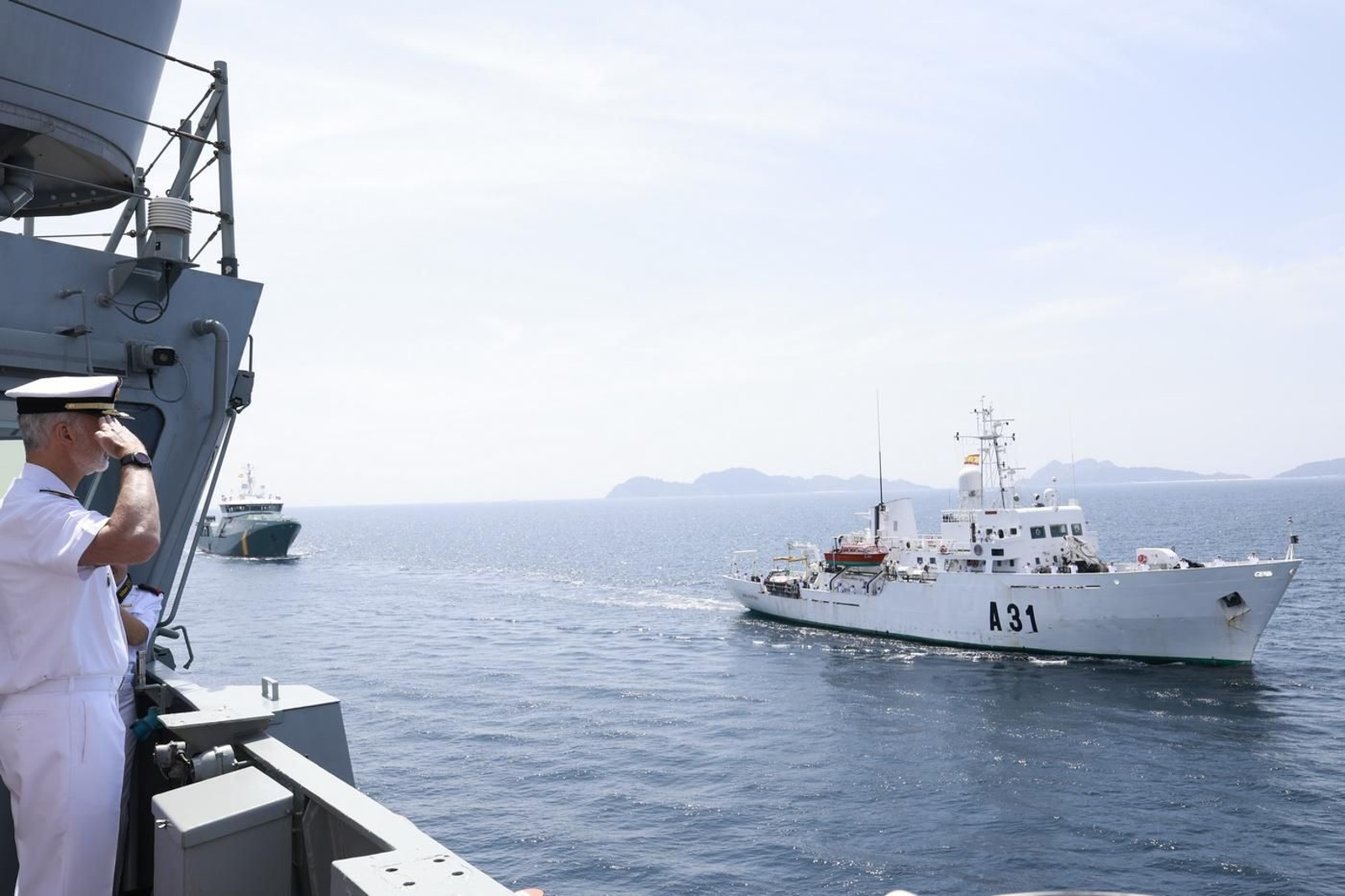 Felipe VI saluda durante la revista naval en aguas de la ría de Vigo.