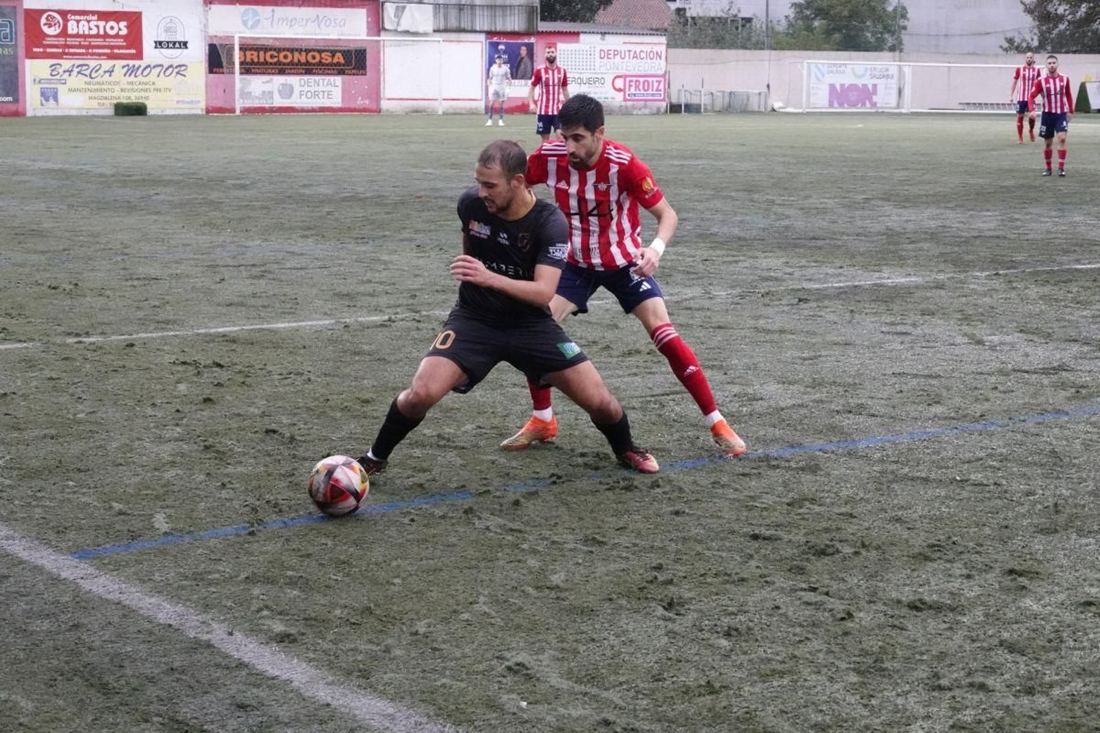 El delantero del Barbadás Ismael aguanta el balón ante la presión de un rival en O Morrazo.