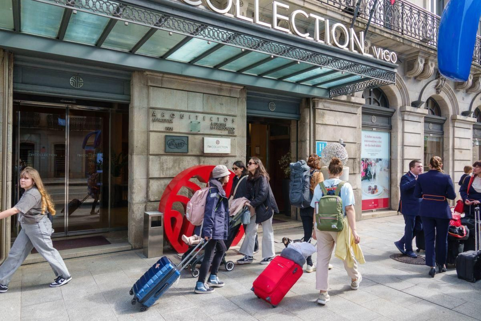 Turistas entran con sus maletas en un hotel céntrico de Vigo.