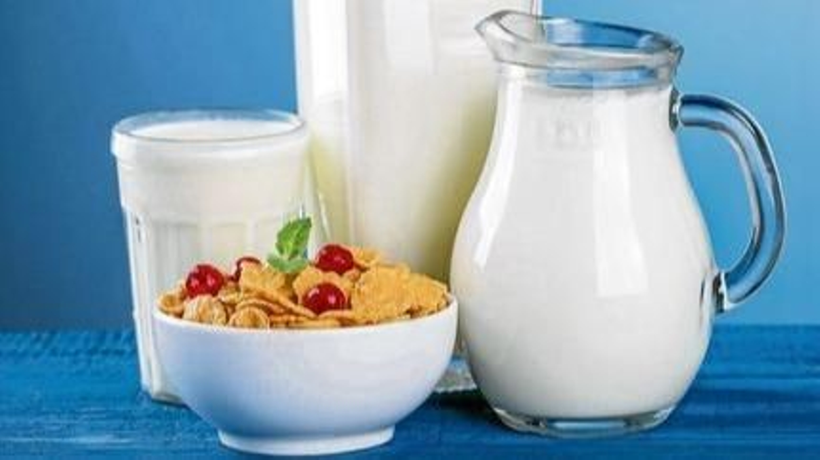 Una jarra y una botella de leche con cereales.