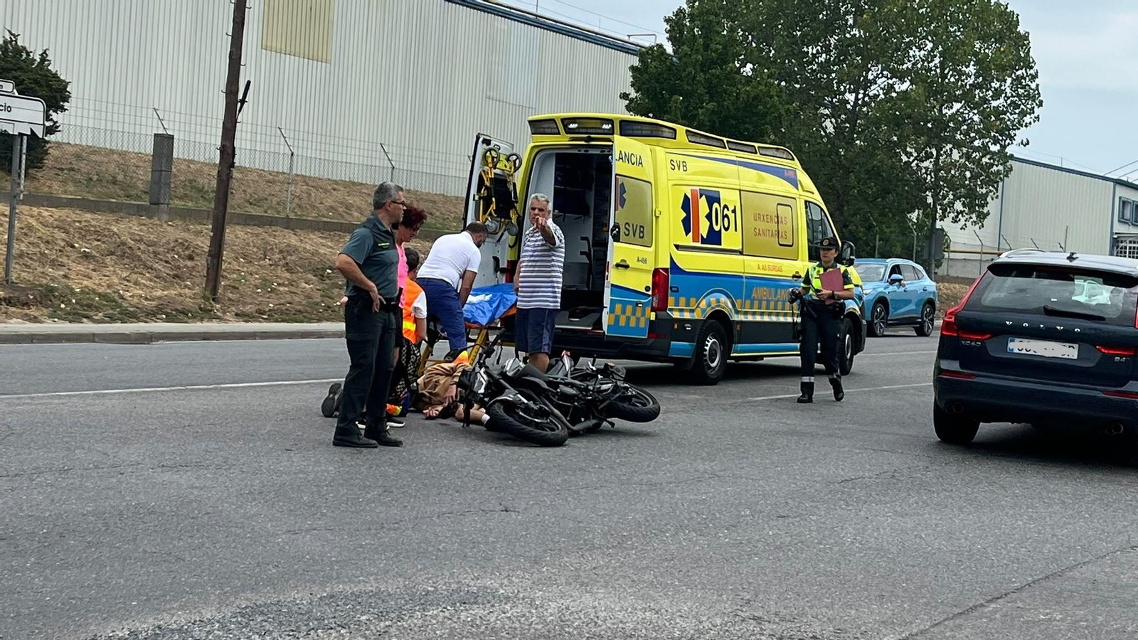 Efectivos de emergencias atienden al motorista herido tras la colisión con un turismo en la OU-0514, a la altura de la calle 3 del polígono de San Cibrao.