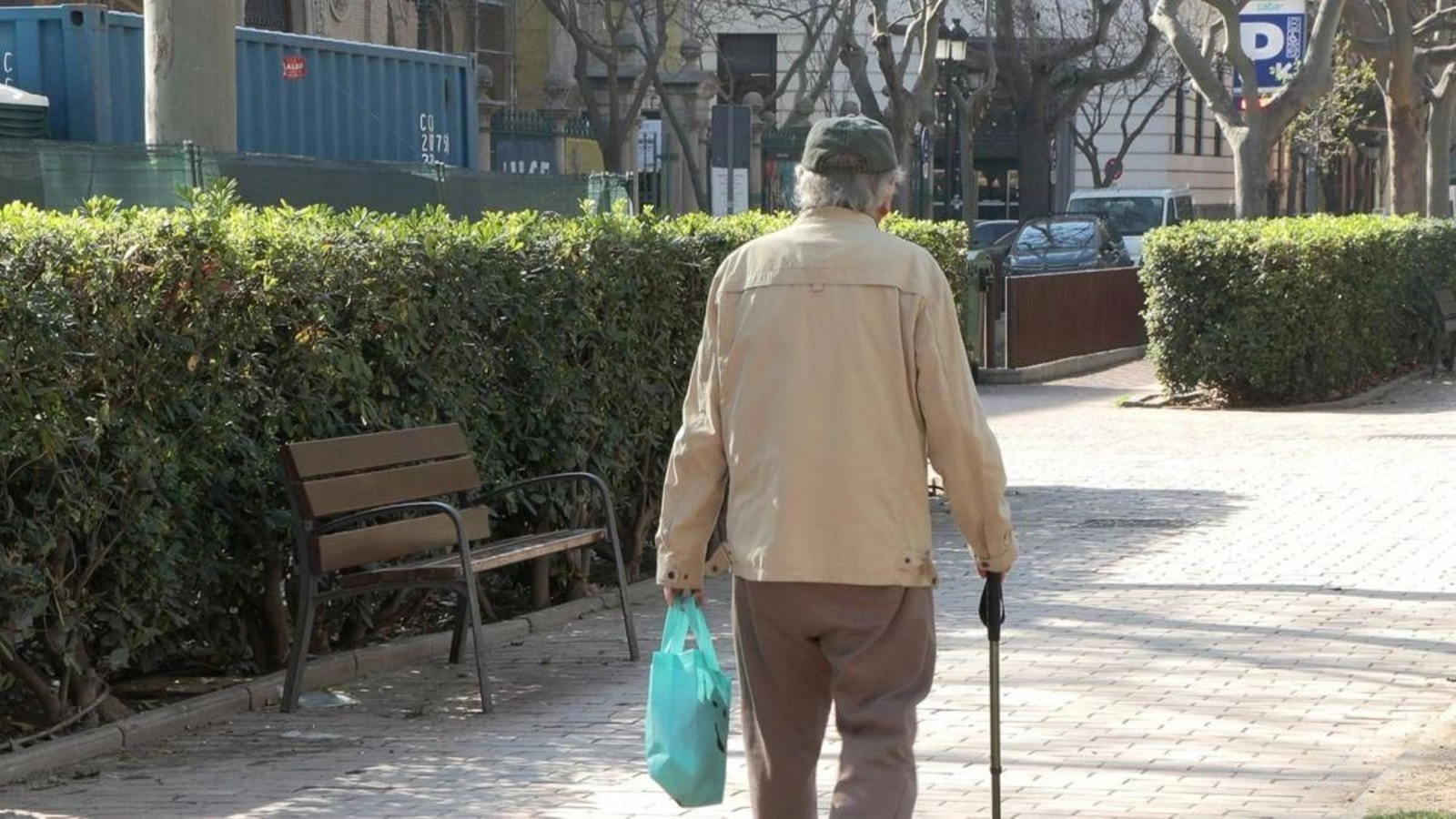 Un jubilado pasea por un parque en Madrid.