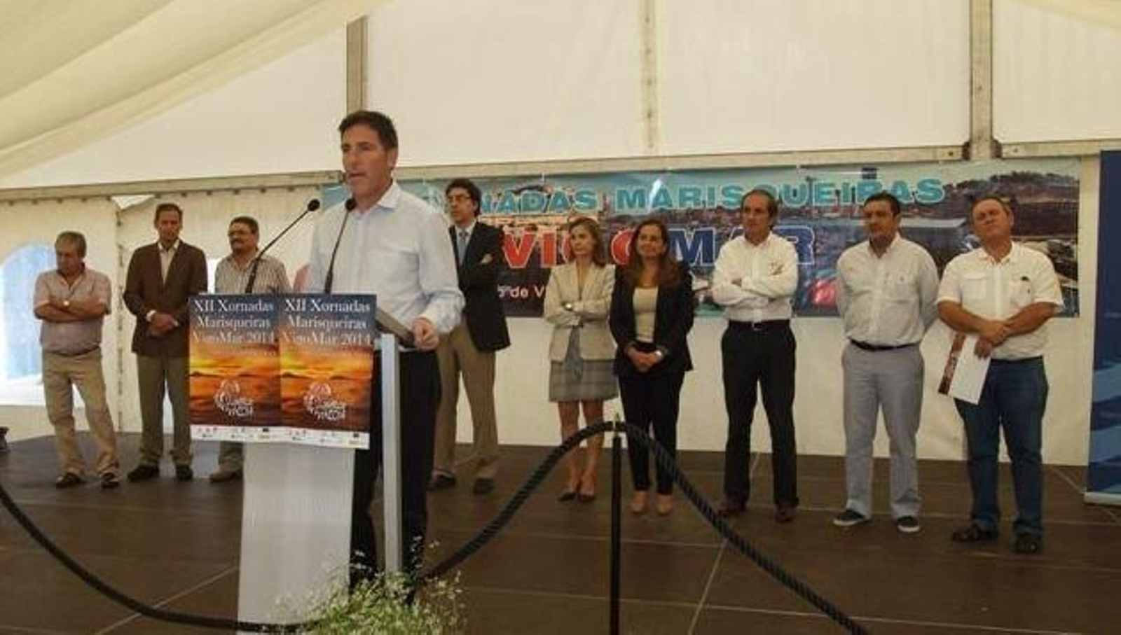 Berizzo, durante su corto pregón, ayer en la carpa en el interior del Berbés. Arriba, observando los precios.
