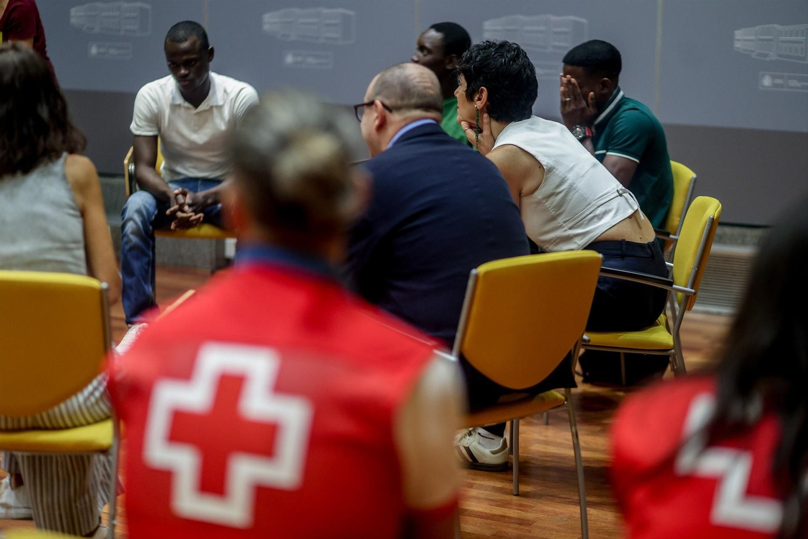 Elma Saiz conversando con un grupo de migrantes