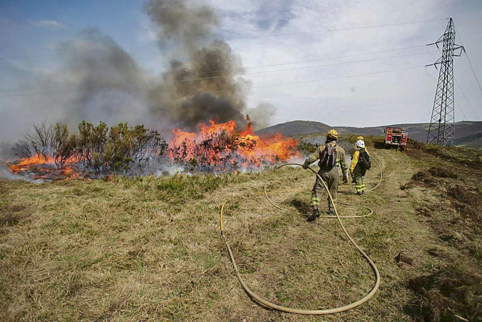 Efectivos de la Xunta trabajan para extinguir las llamas en un incendio forestal, en Lugo.