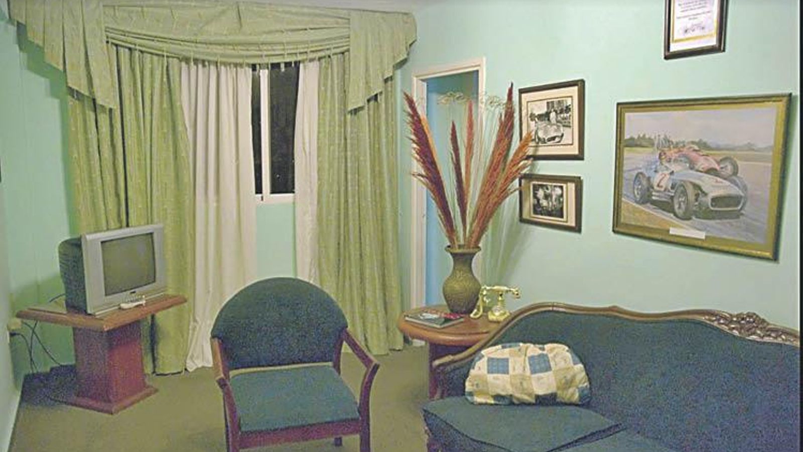 Habitación 810 do hotel Lincoln, coas fotos de Fangio e un diploma de recordo.