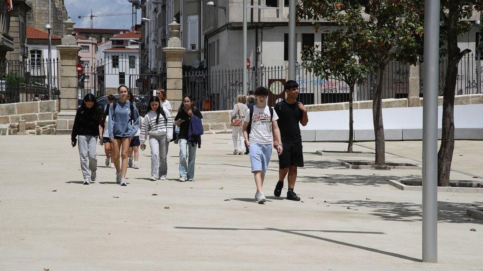 Un grupo de jóvenes paseándose por el cemento del nuevo Jardín del Posío.