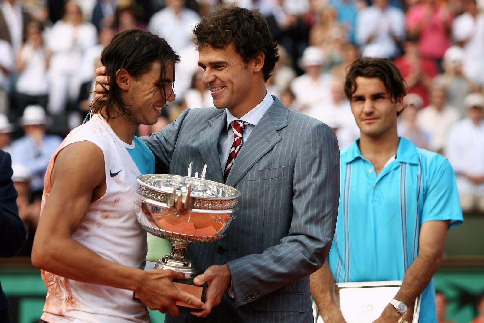 Gustavo Kuerten, el último ganador de tres Roland Garros antes de Nadal, entrega la copa al español. Detrás, un Roger Federer al que había vuelto a ganar en 2007.