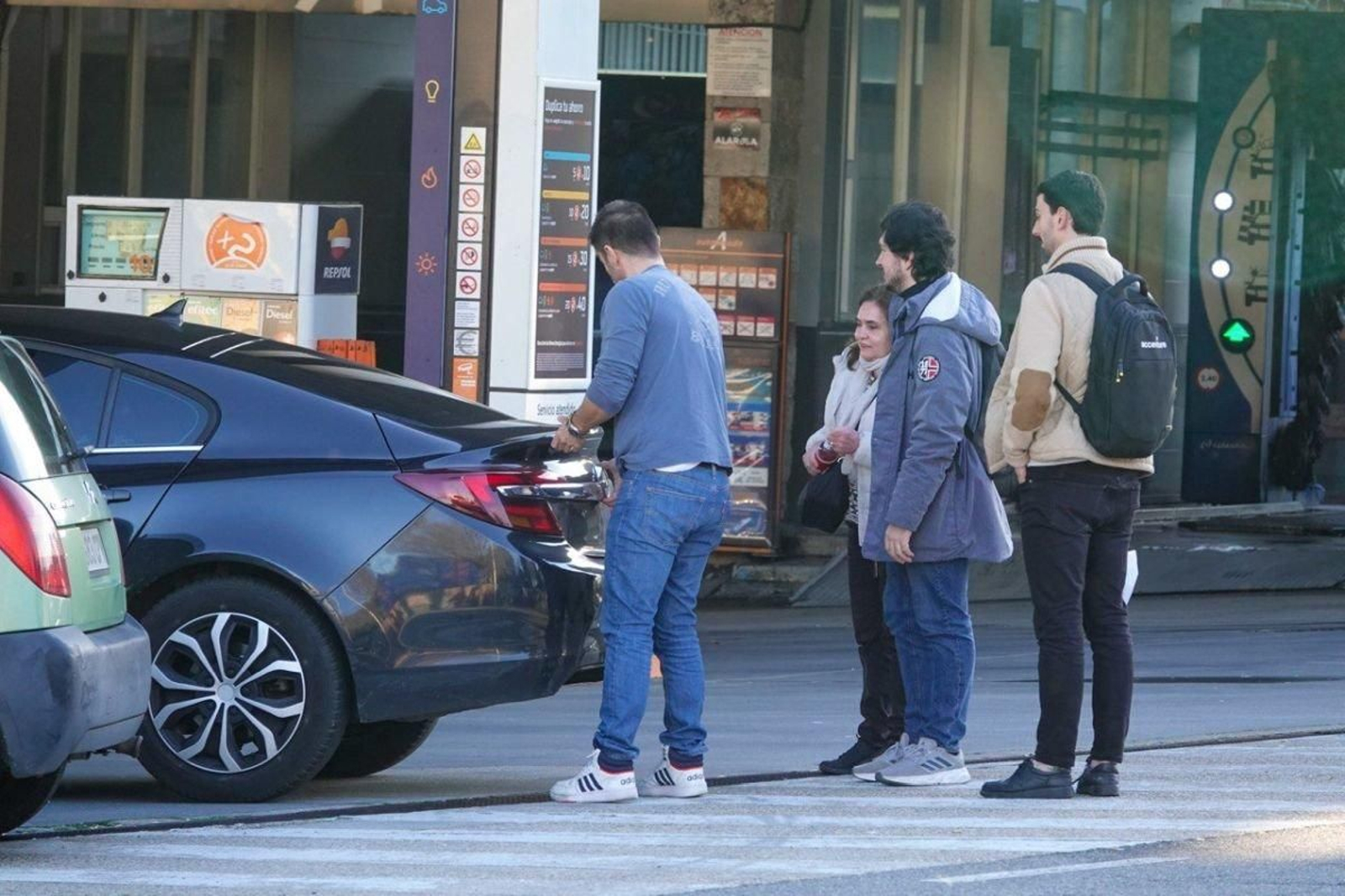 Un grupo de viajeros en coche compartido, preparándose en Praza de España tras dejar el equipaje.