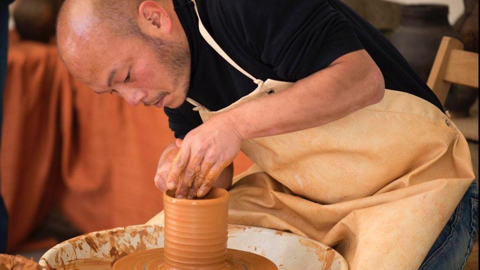 O artista xaponés, traballado nun torno de alfareiro.