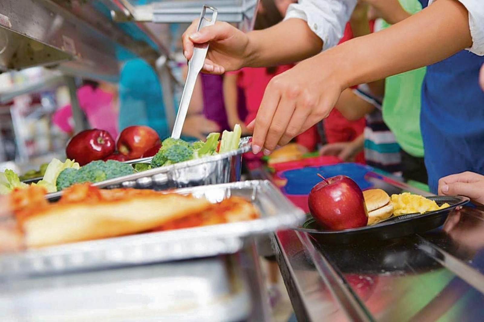 Un estudiante se sirve comida en el comedor de su centro escolar.