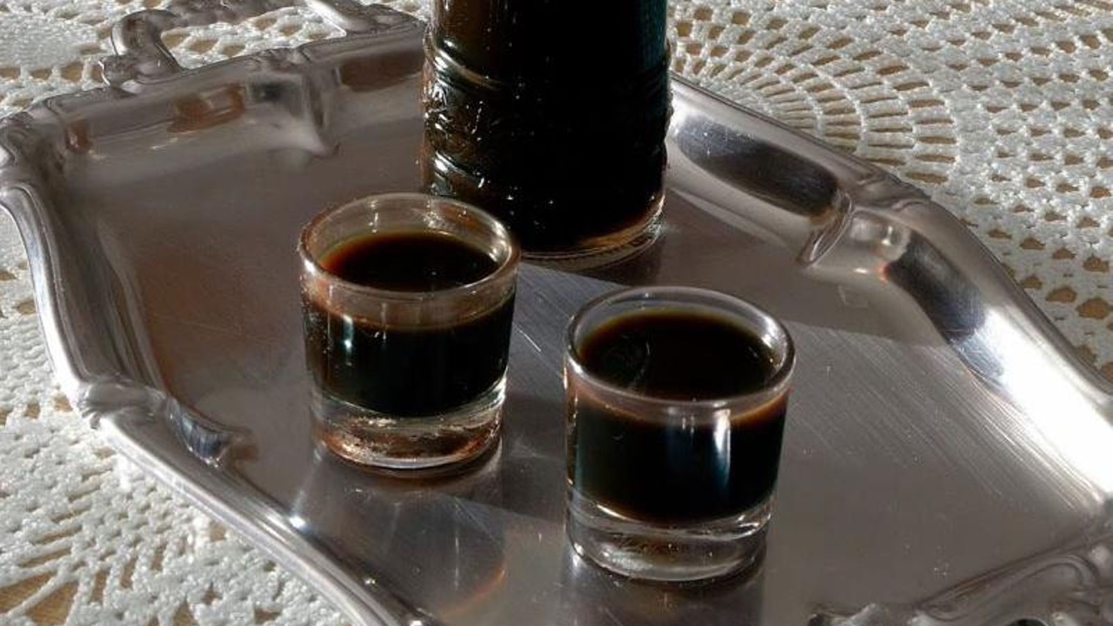 Dos vasos de chupito llenos de licor café.