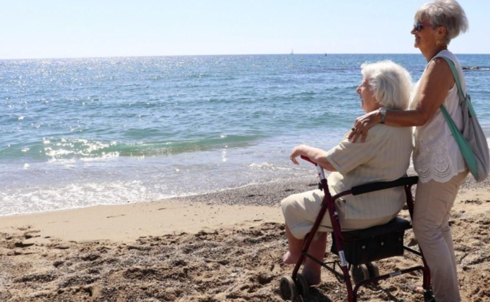 Dos personas mayores disfrutan de una jornada en la playa.