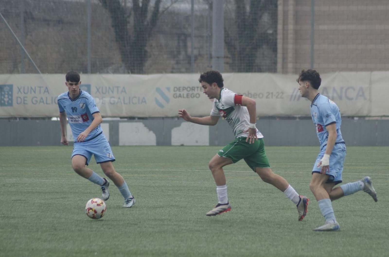 Soriano, capitán del Pabellón, es perseguido por dos jugadores del Coruxo.