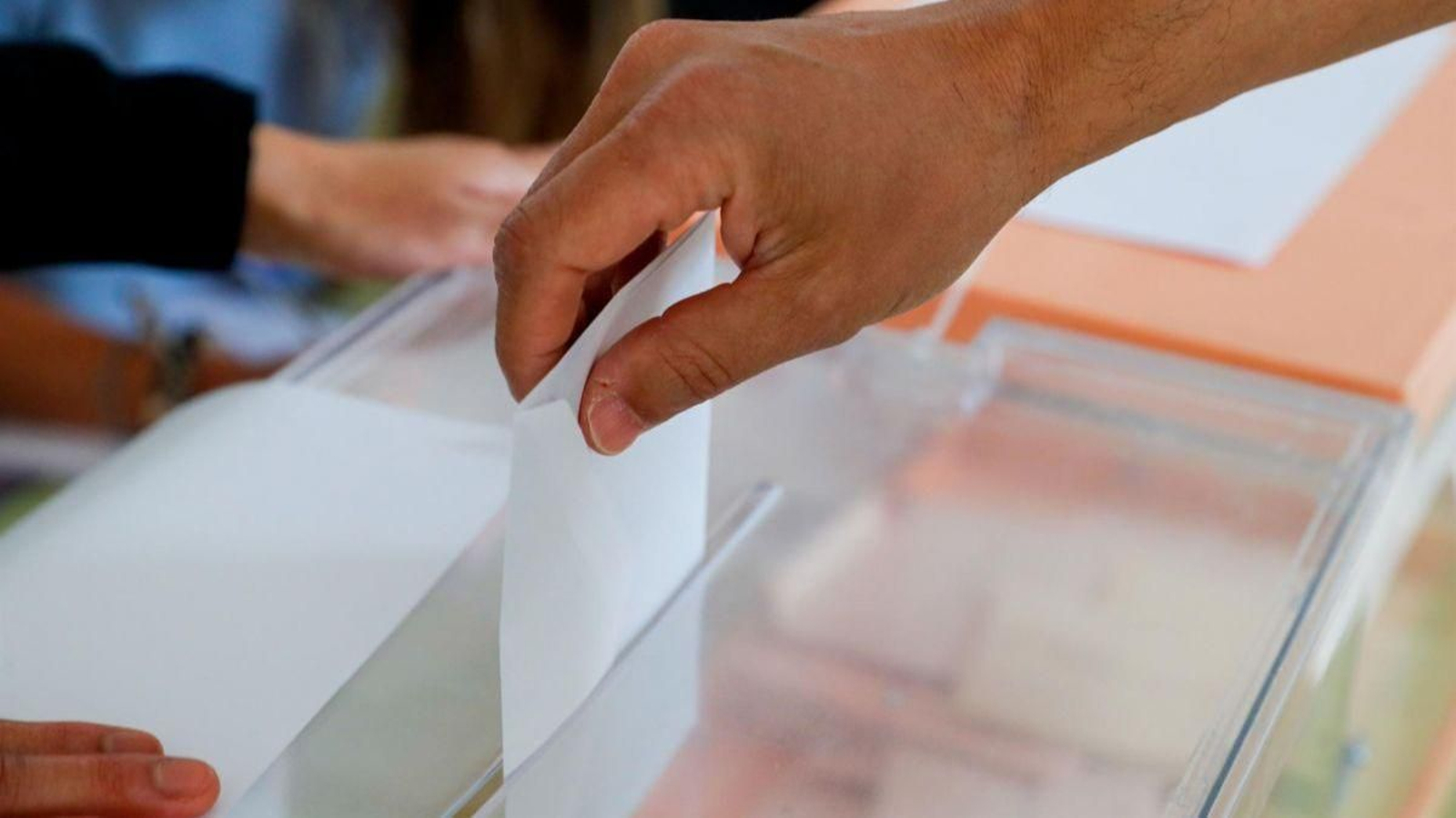 Una persona introduce su voto en la urna.
