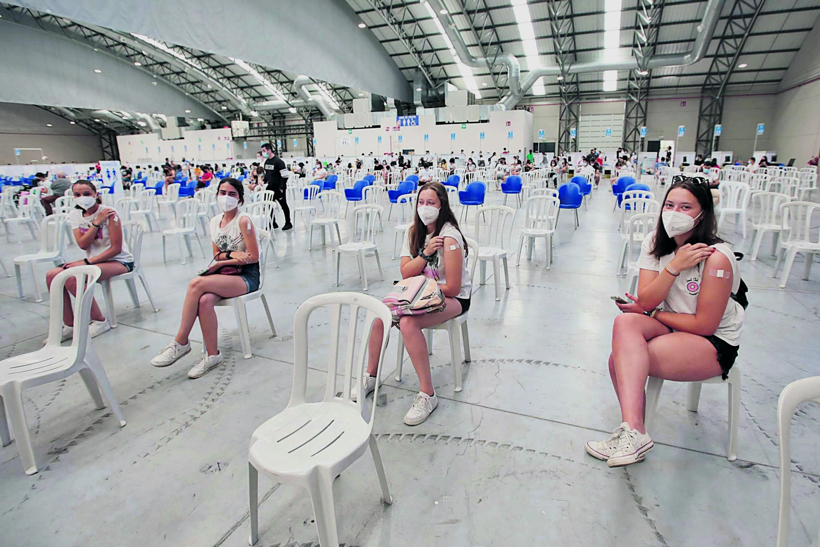 Jóvenes ayer en el recinto ferial vigués esperando los quince minutos de rigor tras recibir el pinchazo.