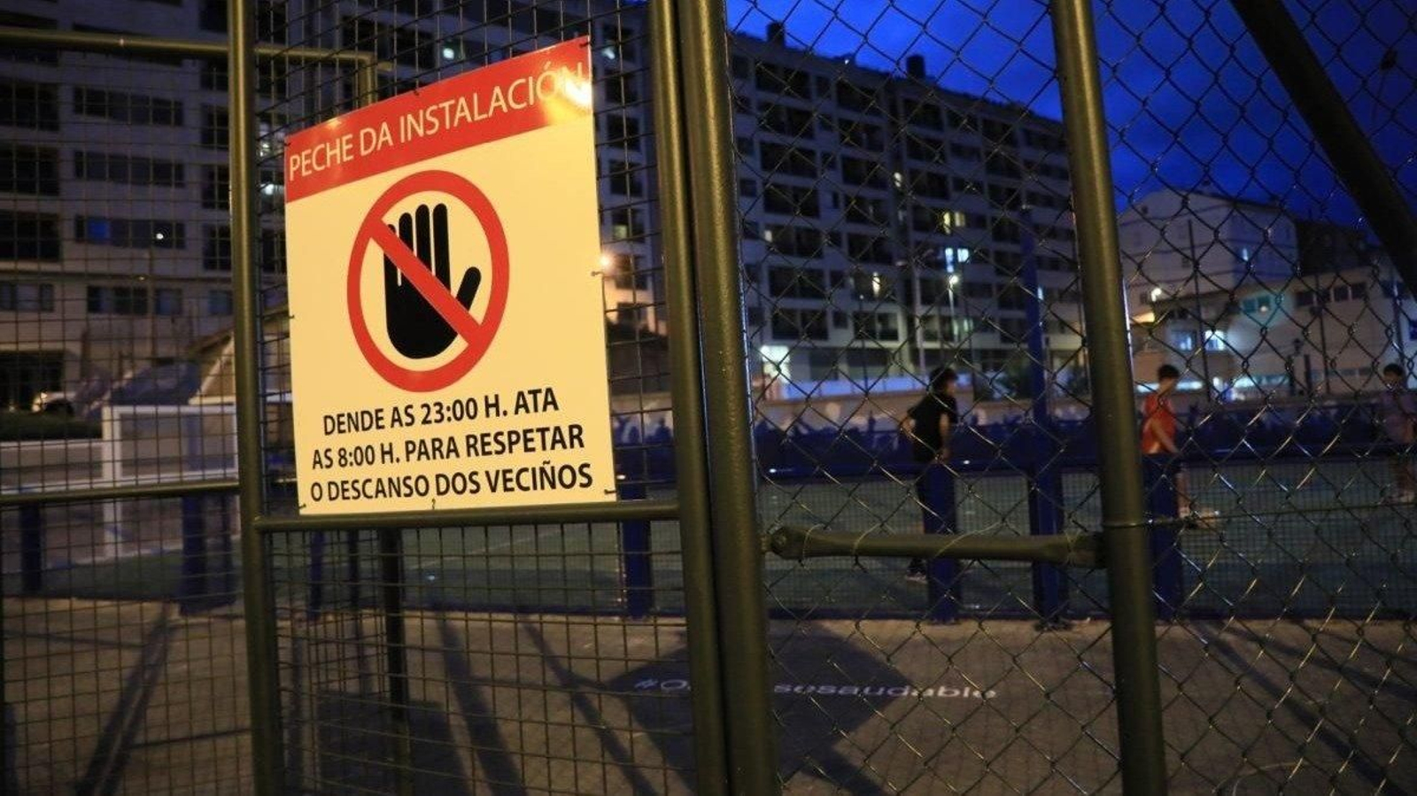 Cartel en la pista de Cruz Alta, este lunes, con jóvenes jugando. (Foto: José Paz)