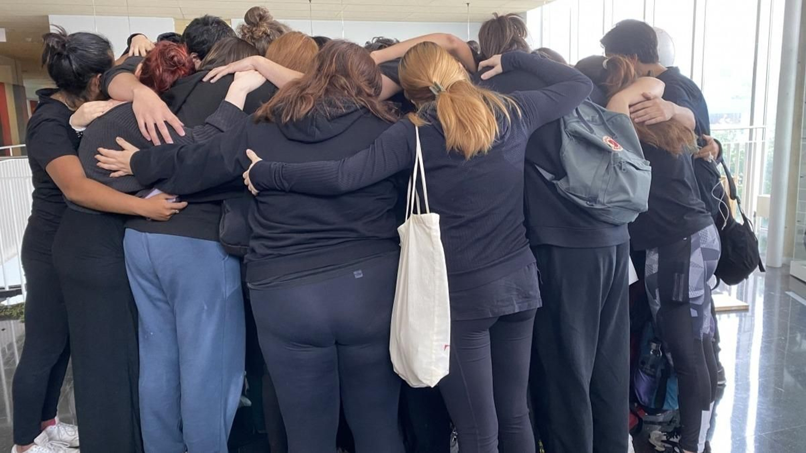 Momento en el que los compañeros abrazan a las alumnas denunciantes durante la concentración.