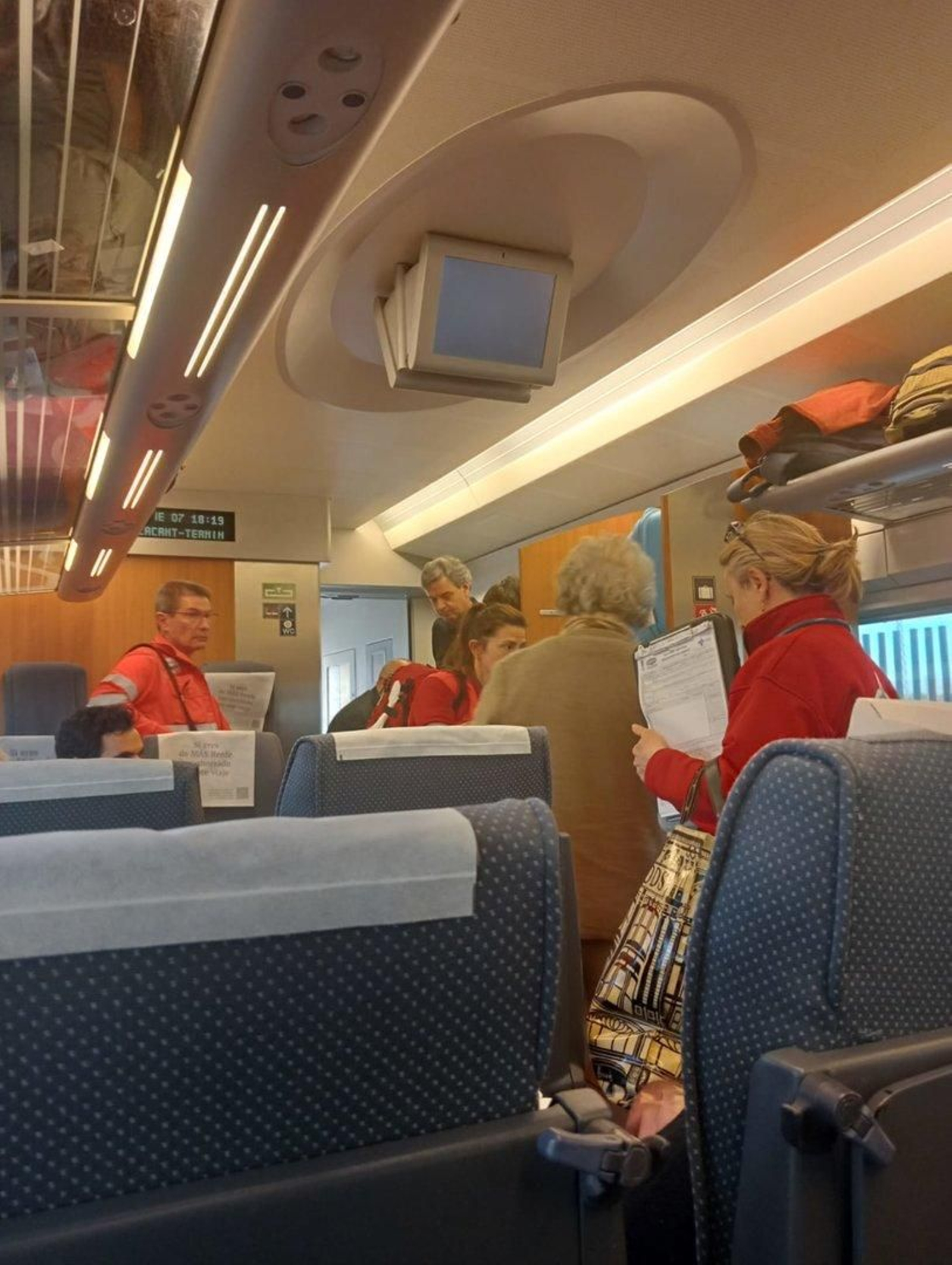 La mujer, de espaldas con una chaqueta marrón, abandona el tren.