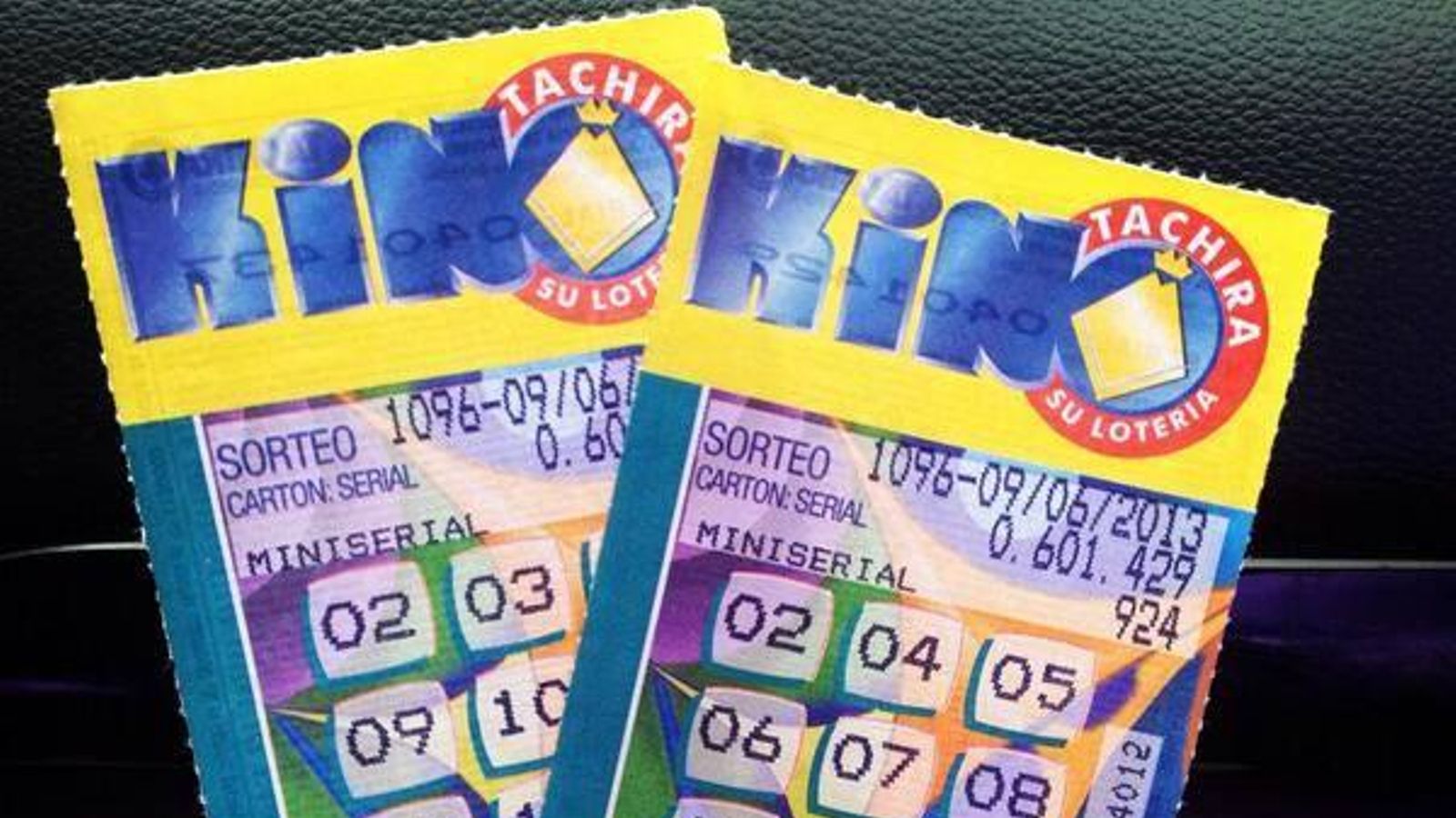 Una persona sujeta dos papeletas de Kino Táchira