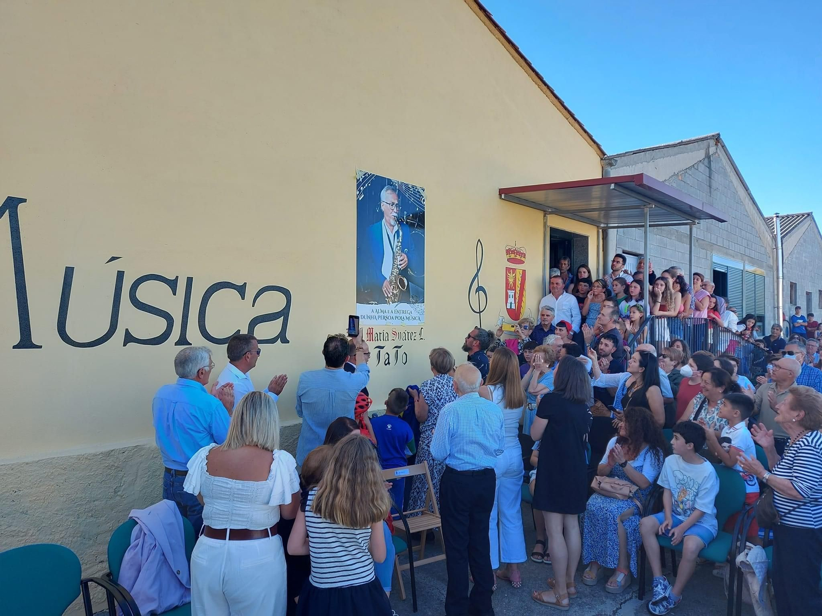 Músicos y vecinos presencian el homenaje a José María Suárez Lemos.