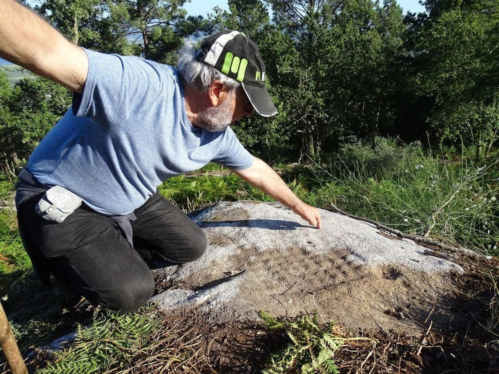 Cándido Verde señala uno de los petroglifos que descubrió en uno de sus paseos por el Torroso.