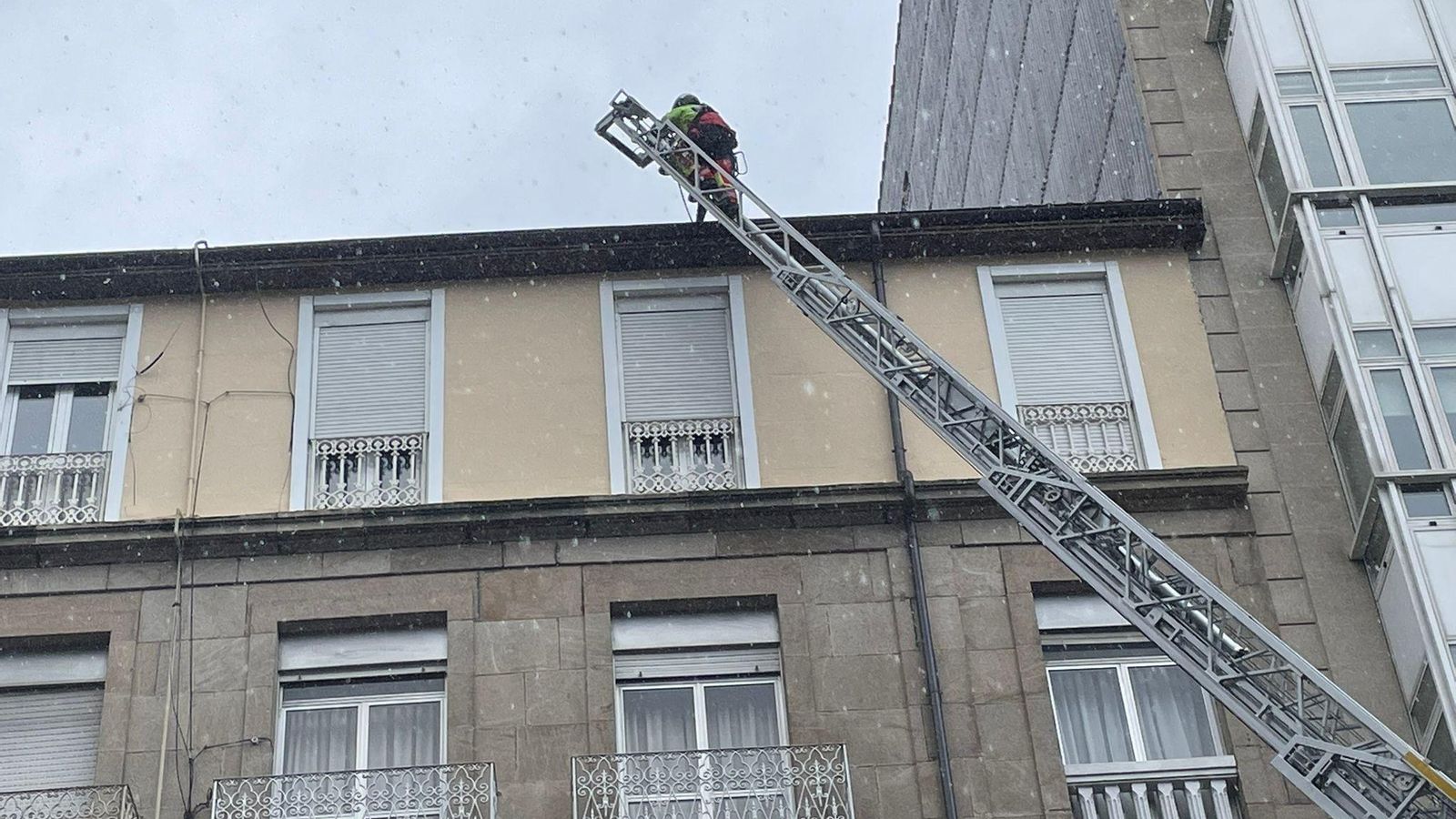 Momento en el que los bomberos se subían al tejado para retirar la mesa