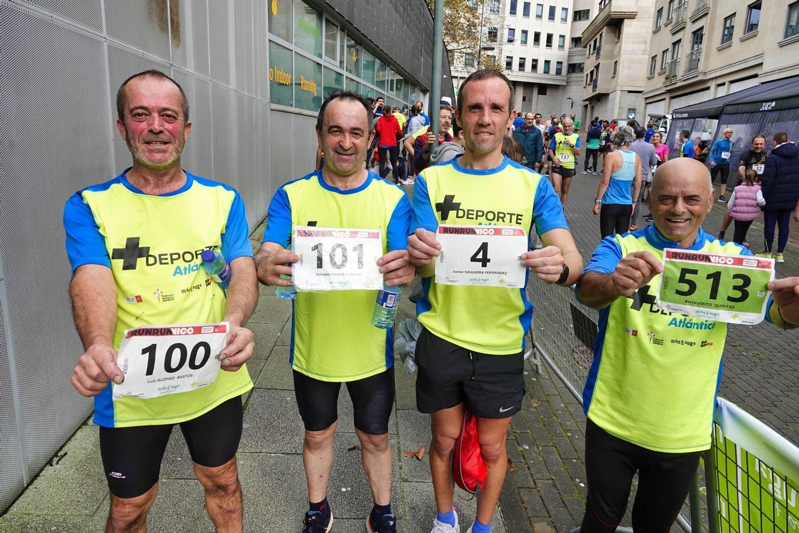 Participantes en la Vigo+11 en Coia muestran sus dorsales.