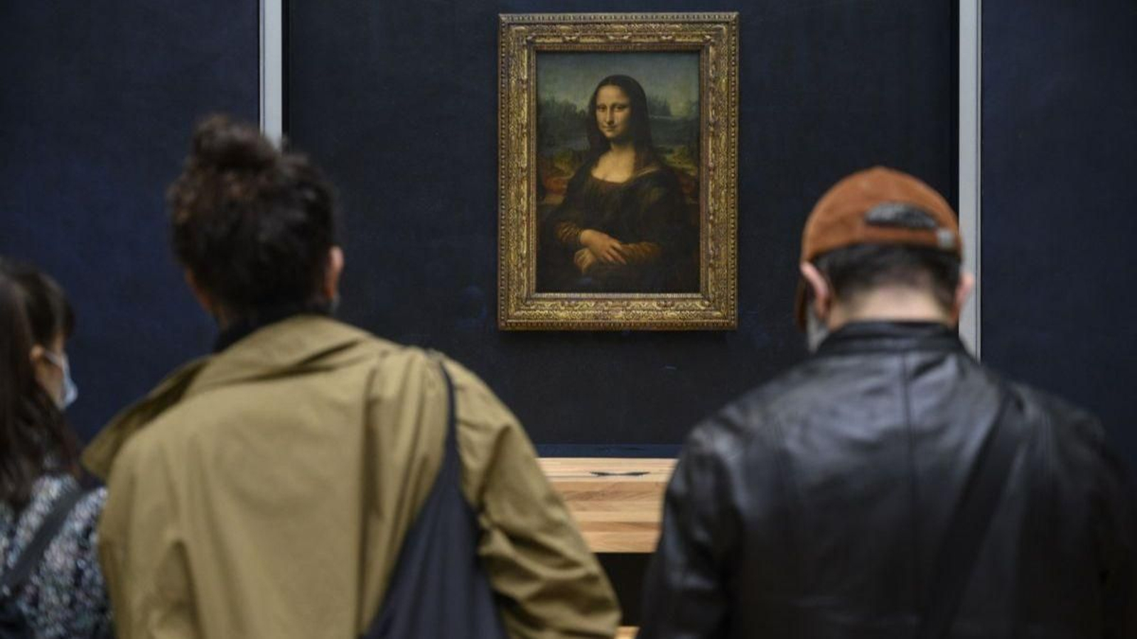 Visitantes admiran la Mona Lisa de Leonardo da Vinci en el Louvre.
