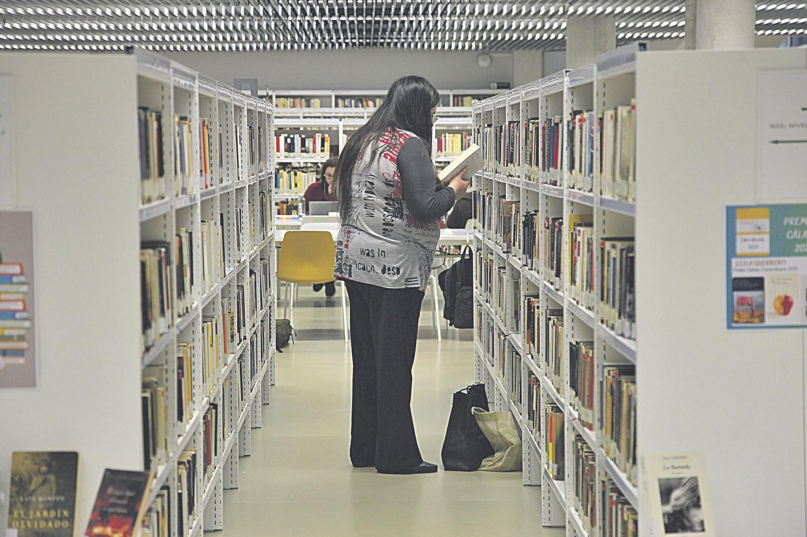Usuaria de la Biblioteca Nós eligiendo un libro recomendado.