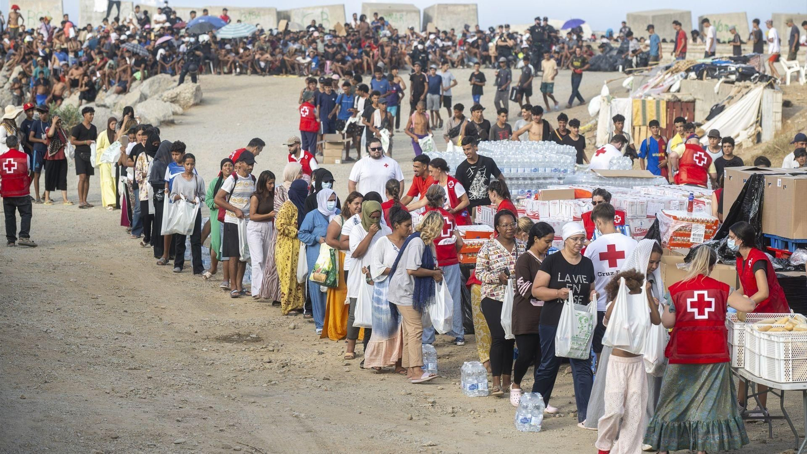 Cruz Roja reparte comida en la playa de El Trampolín, en Ceuta.